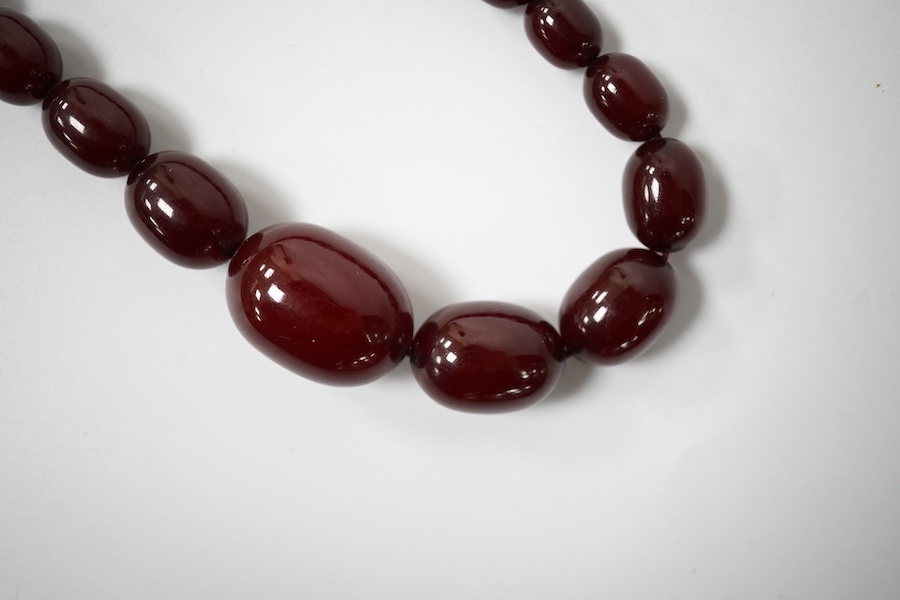 A single strand graduated simulated cherry amber bead necklace, 68cm, gross weight 44 grams. Condition - fair to good